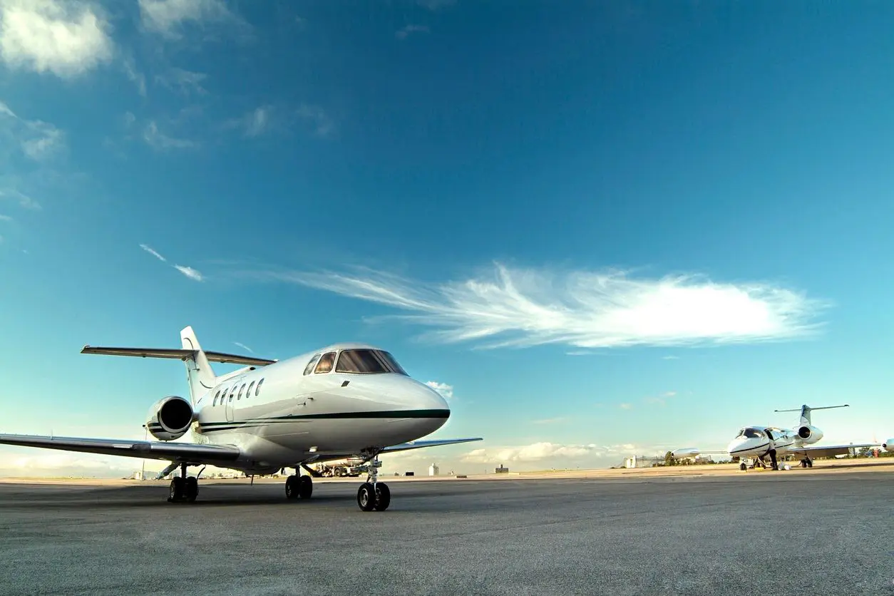 A white airplane sitting on top of an airport runway.